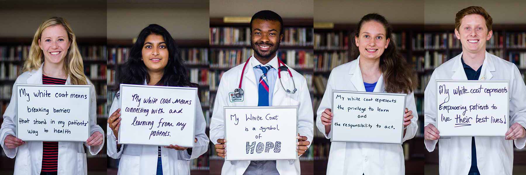 Incoming medical students hold signs stating what their white coat means to them.